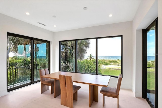 tiled dining space with plenty of natural light and a water view