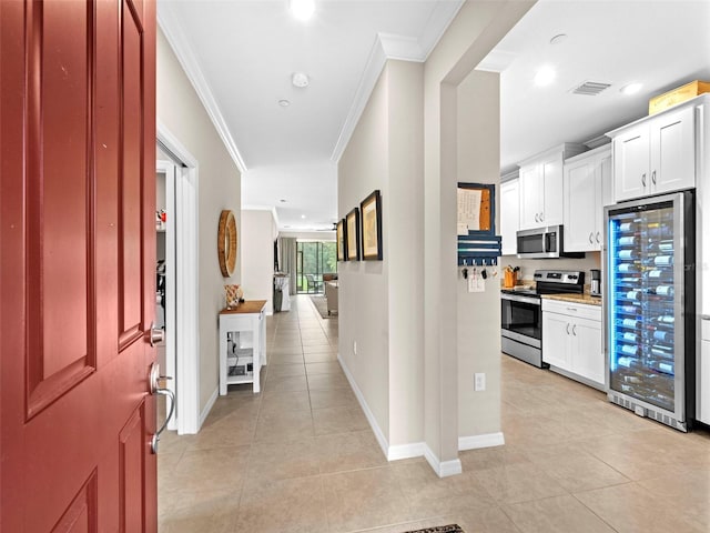 corridor featuring light tile patterned floors and crown molding