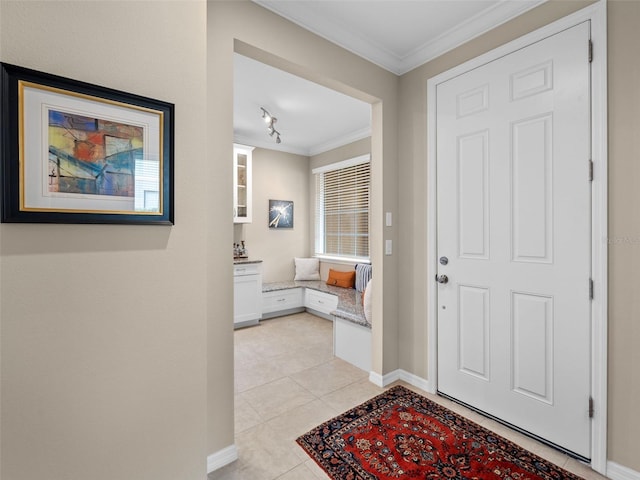 tiled foyer with crown molding and rail lighting