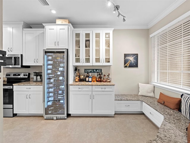 kitchen featuring light stone countertops, white cabinetry, and appliances with stainless steel finishes