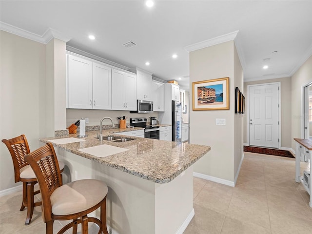 kitchen featuring a kitchen bar, sink, white cabinetry, kitchen peninsula, and stainless steel appliances