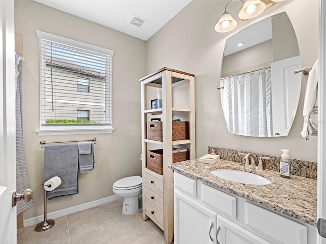 bathroom with tile patterned flooring, vanity, and toilet