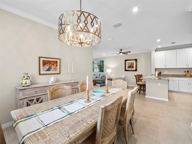 tiled dining room featuring sink, crown molding, and ceiling fan with notable chandelier