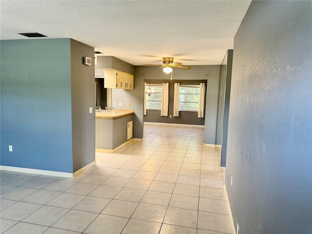 kitchen with light tile patterned flooring, sink, and ceiling fan