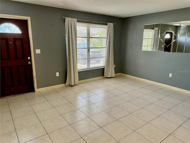 foyer entrance featuring light tile patterned floors and a textured ceiling