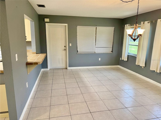 interior space with an inviting chandelier and light tile patterned floors