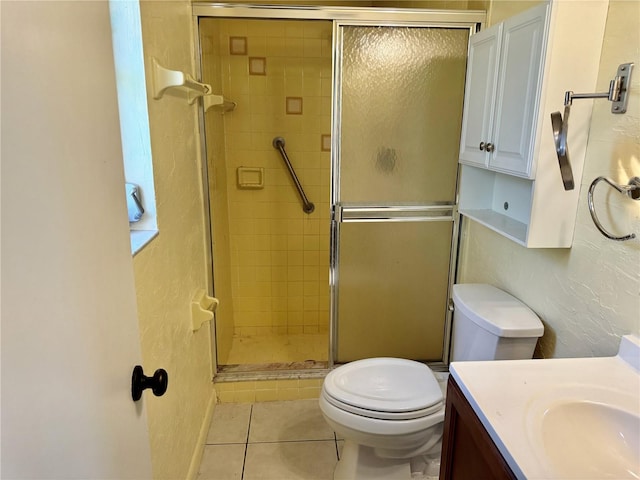 bathroom with vanity, toilet, tile patterned flooring, and an enclosed shower