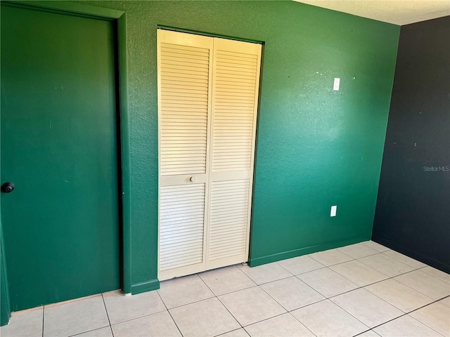 unfurnished bedroom with tile patterned floors and a closet