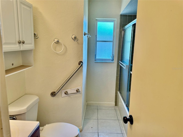 full bathroom featuring tile patterned flooring, bath / shower combo with glass door, toilet, and vanity