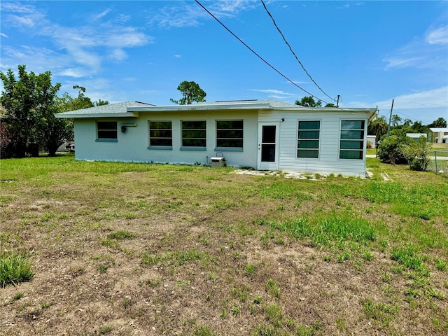 rear view of property featuring a yard