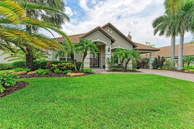 mediterranean / spanish-style house featuring a front lawn