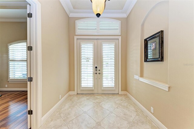 foyer entrance with light wood-type flooring, crown molding, french doors, and a wealth of natural light