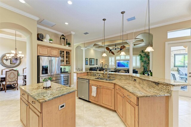 kitchen featuring sink, a large island, appliances with stainless steel finishes, and hanging light fixtures