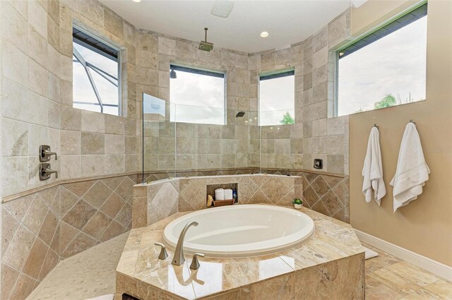 bathroom with tile patterned flooring, tile walls, and independent shower and bath