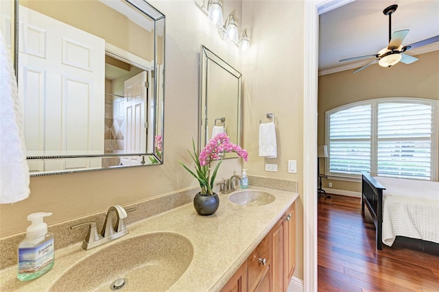 bathroom featuring wood-type flooring, dual vanity, crown molding, and ceiling fan