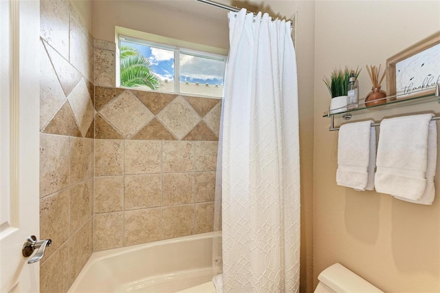 bathroom featuring shower / bathtub combination with curtain and toilet