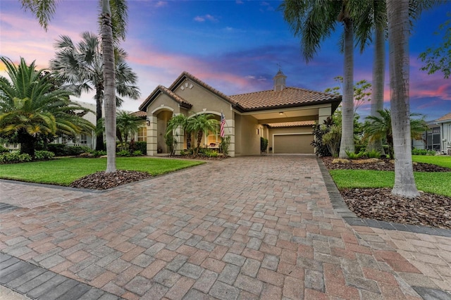 mediterranean / spanish home with a garage and a yard