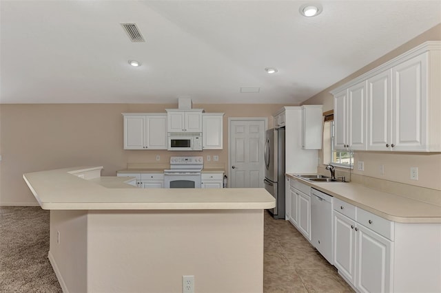 kitchen with white cabinetry, sink, an island with sink, and white appliances