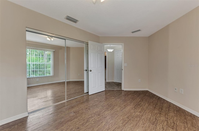 unfurnished bedroom featuring hardwood / wood-style floors and a closet