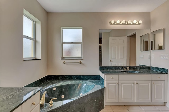 bathroom with tiled bath, vanity, and tile patterned floors