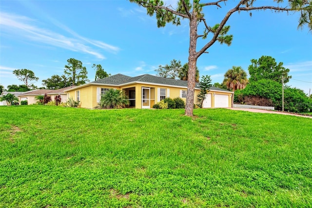 ranch-style house featuring a garage, a front yard, concrete driveway, and stucco siding