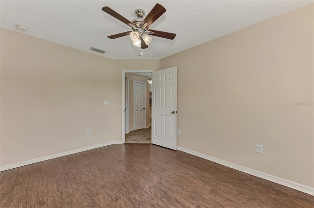 empty room featuring ceiling fan and dark wood-type flooring