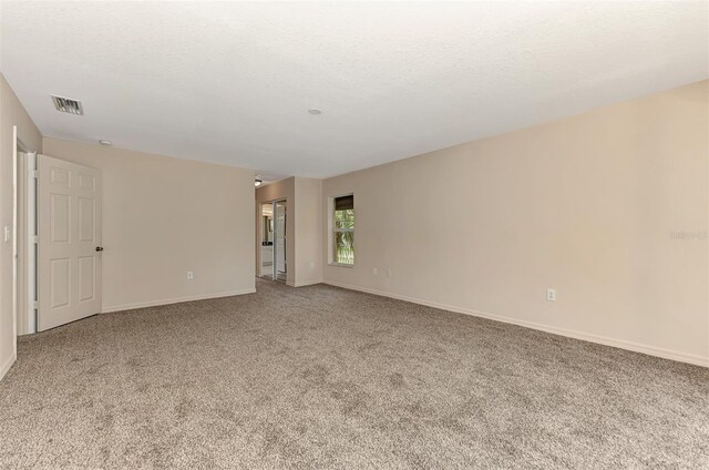 carpeted spare room with a textured ceiling