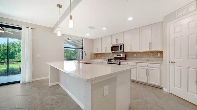 kitchen featuring pendant lighting, decorative backsplash, sink, stainless steel appliances, and white cabinets