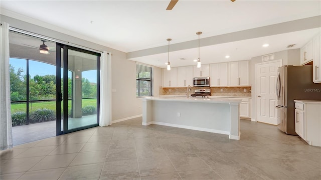 kitchen featuring ceiling fan, stainless steel appliances, white cabinetry, and hanging light fixtures