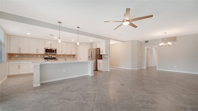 kitchen with appliances with stainless steel finishes, decorative backsplash, white cabinets, and hanging light fixtures