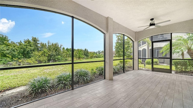 unfurnished sunroom featuring ceiling fan