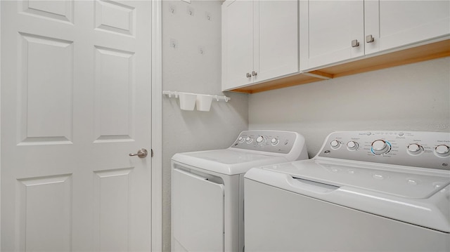 laundry area featuring washing machine and dryer and cabinets