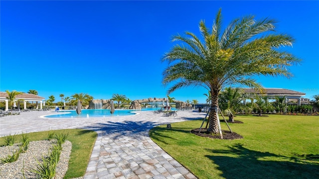 view of swimming pool featuring a patio area, a gazebo, a yard, and pool water feature