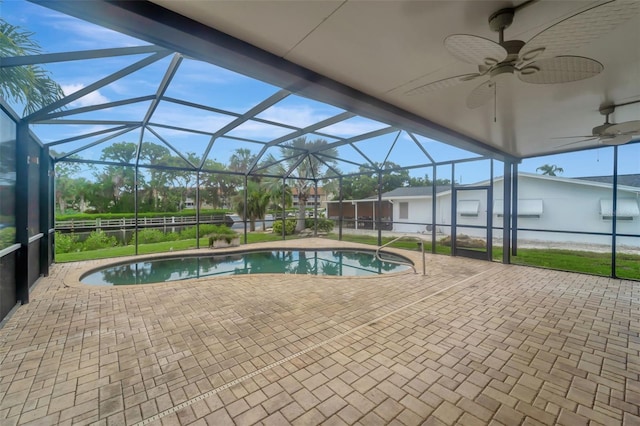 view of swimming pool featuring ceiling fan, a patio area, and glass enclosure