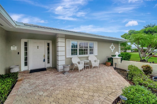 entrance to property featuring a patio