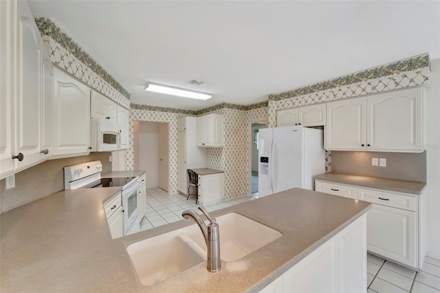 kitchen featuring light tile patterned flooring, sink, kitchen peninsula, white appliances, and white cabinets