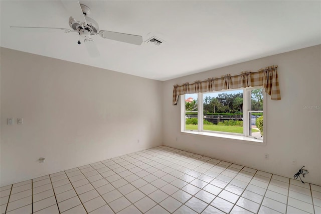 tiled empty room featuring ceiling fan