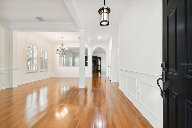 entrance foyer featuring a notable chandelier, light hardwood / wood-style floors, and crown molding