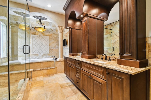 bathroom featuring vanity, ornate columns, and shower with separate bathtub