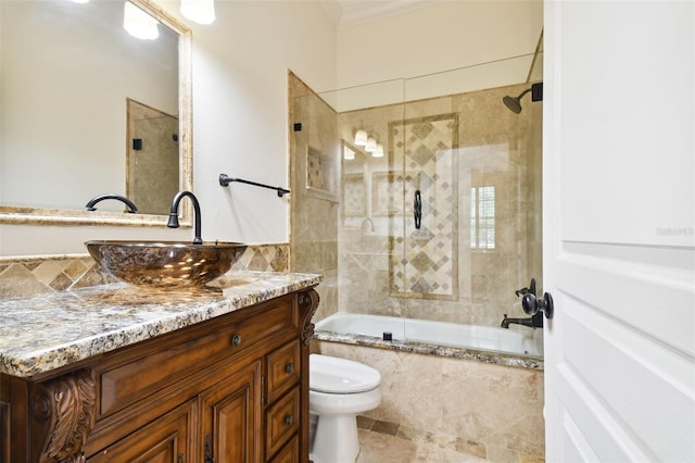 full bathroom featuring vanity, toilet, and bath / shower combo with glass door