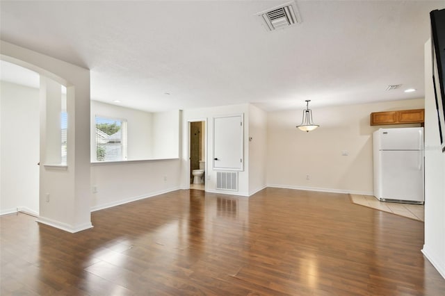 unfurnished living room with dark wood-type flooring