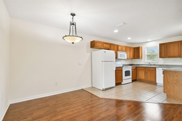 kitchen featuring light hardwood / wood-style floors, sink, white appliances, and hanging light fixtures