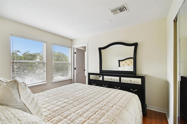 bedroom with a closet and dark hardwood / wood-style floors