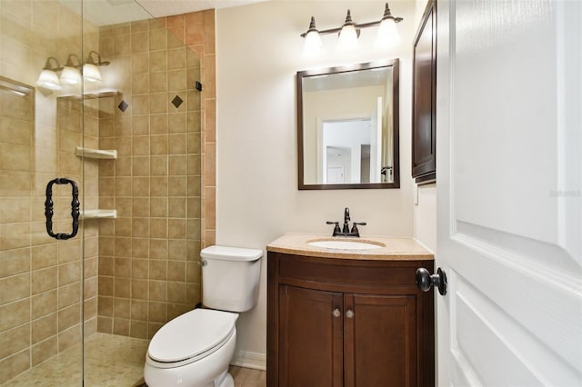 bathroom featuring vanity, toilet, and a shower with door