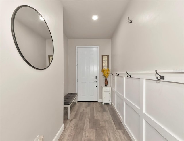 doorway featuring baseboards and light wood-style flooring