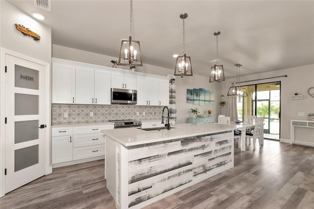 2352 Marton Oak Blvd, North Port, FL 34289 - kitchen with a sink, appliances with stainless steel finishes, a chandelier, tasteful backsplash, and light countertops