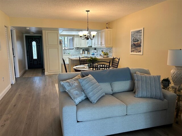 living room featuring hardwood / wood-style flooring, a textured ceiling, and an inviting chandelier