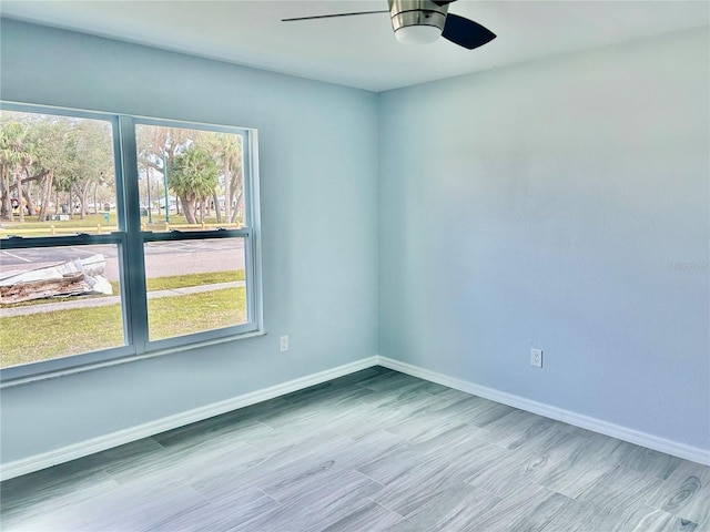 spare room featuring baseboards, a ceiling fan, and wood finished floors