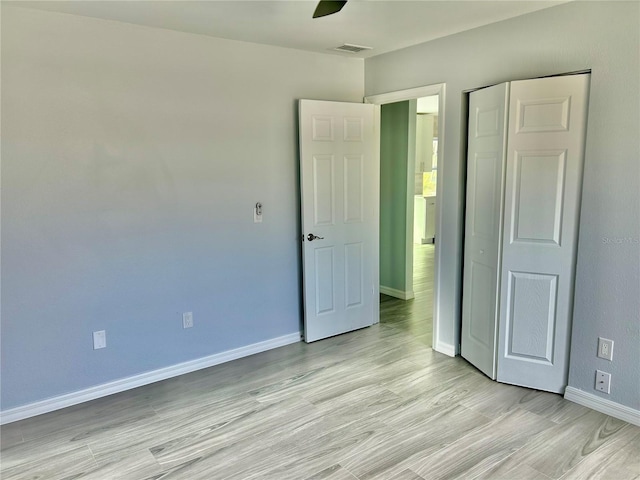 unfurnished bedroom featuring light wood-type flooring, visible vents, baseboards, and a ceiling fan