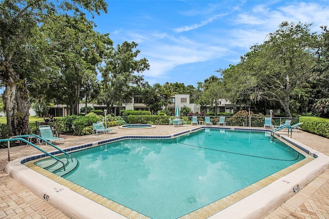 view of pool with a hot tub and a patio